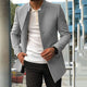 A man wearing a smart men's coat in beige color, paired with a white t-shirt and black trousers.